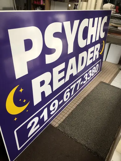 Purple storefront sign with large lettering and a moon graphic
